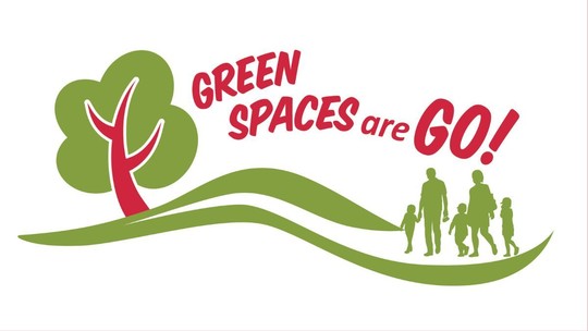 The words Green Spaces are Go and am image of a tree on the left, and a family on the right, in green and red