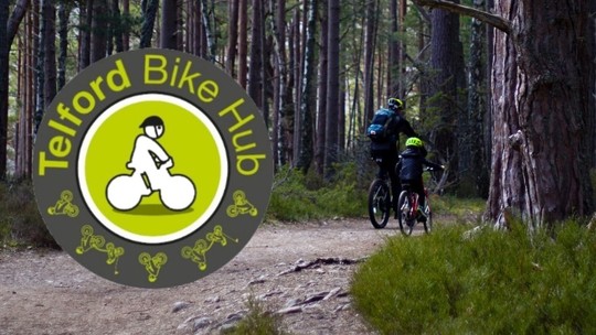A man and boy cycling away into woodland. The Telford Bike Hub logo overlaid on the left.