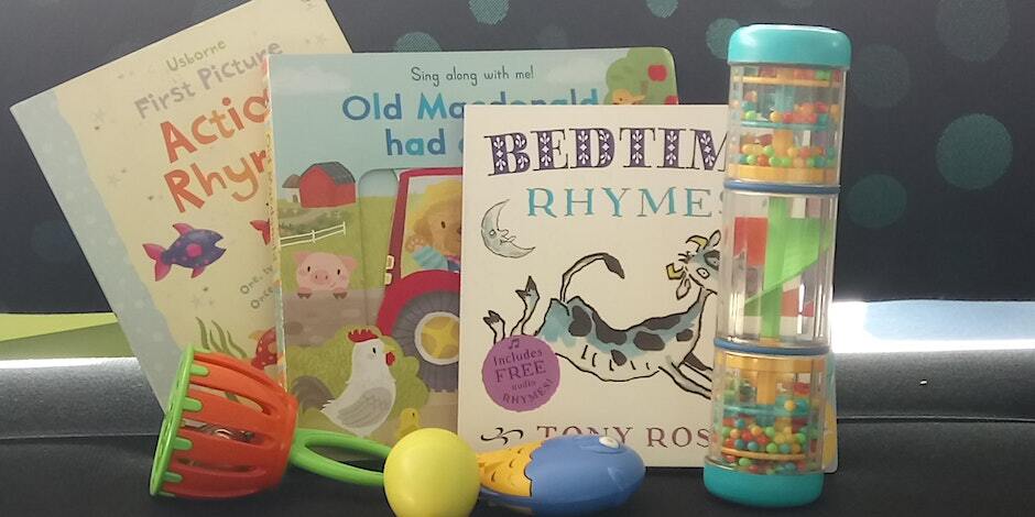 A selection of children's picture books and brightly coloured rattles and rain-makers