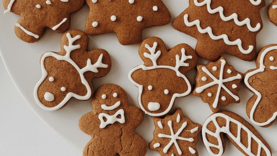 Gingerbread biscuits on a white place. The biscuits are in the shapes of reindeers, stars, men and candy canes