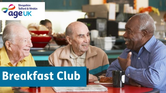 3 older men sit around a table chatting with animation. The background, while blurred, suggests a cafe.
