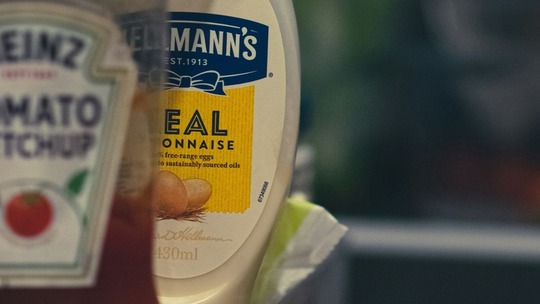 Bottles of tomato ketchup and mayonnaise in a fridge door