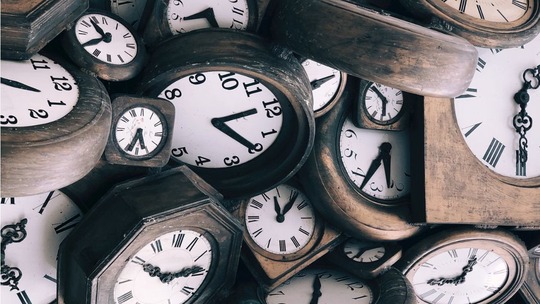 Lots of old wooden clocks heaped on top of one another