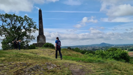 Photo of 3 walkers at the top of Lilleshall Hill on a beautiful summer's day