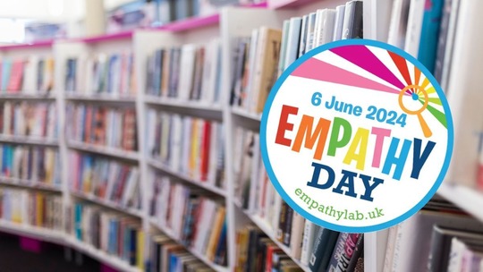 A blurred photo of library bookshelves over which the Empathy Day logo is laid