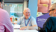 Support team member advising two learners at a table at the Adult Learning Service.