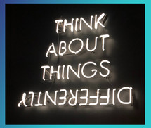 Neon text: Think about things differently. The word differently is upside down.