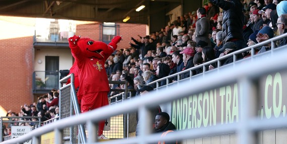 Leyton Orient's red dragon mascot interacts with the crowd at Brisbane Road