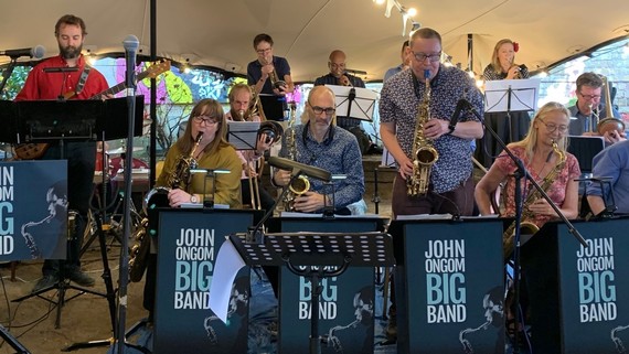 The John Ongom Big Band play in a marquee