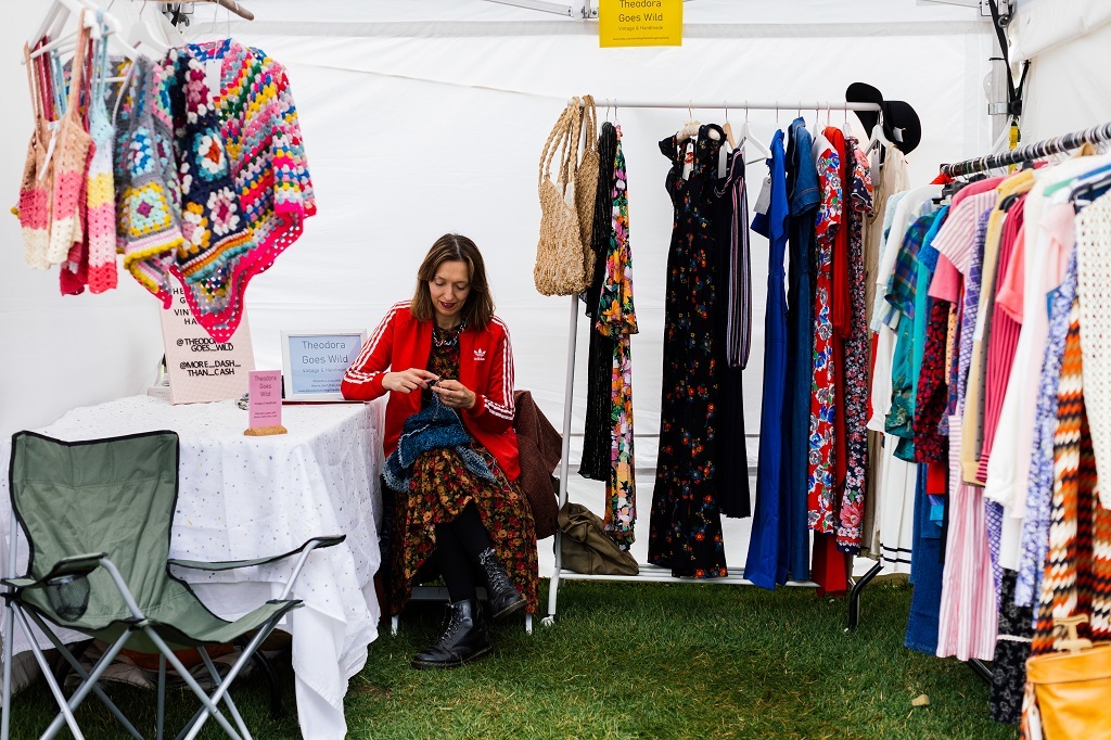 Fashion market stallholder surrounded by clothes