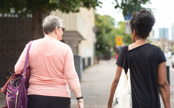 Two women seen from behind, walking down the street