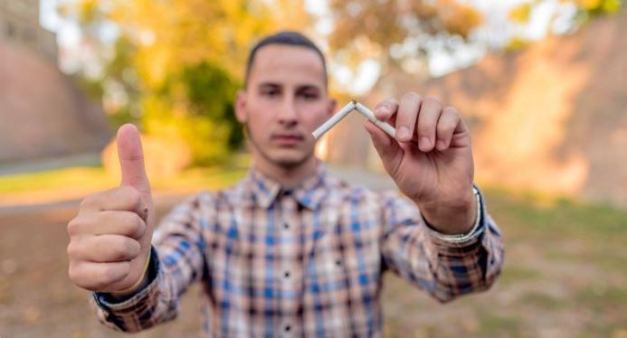 Man gives thumbs up as he poses with broken cigarette