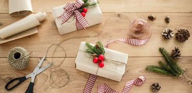 Wrapped up christmas presents on table with wrapping material