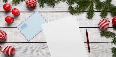 letter and envelope surrounded by christmas tree leaves and baubles