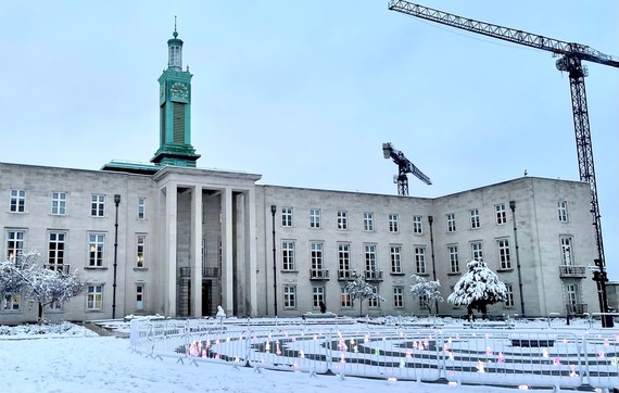 The Town Hall in the snow with the Fellowship Square fountains illuminated in front