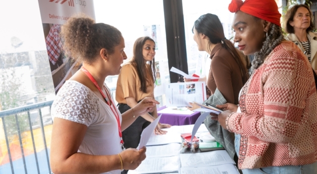 People talking to representatives from companies at a job fair