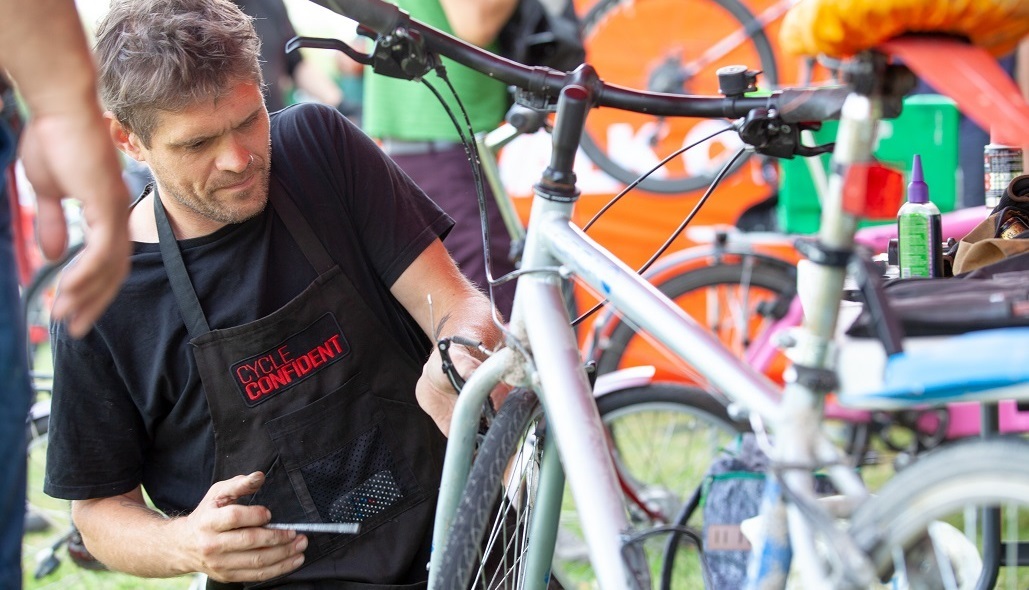 A bike being worked on by someone in a Cycle Confident apron