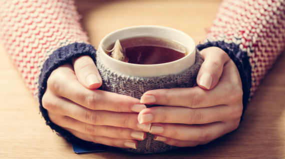 Two hands holding a cup of tea