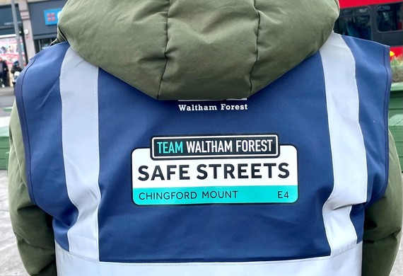 Close up on Team Waltham Forest Safe Streets Chingford Mount high vis jacket from behind
