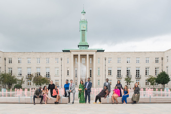 A group of couples pose in front of the fountain in Fellowship Square