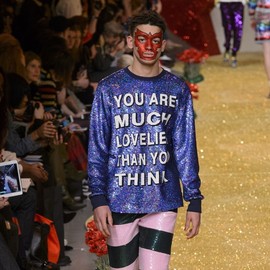 Man wearing a sequined top that says 'you are much lovelier than you think'