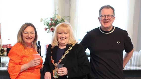 The Mayor makes a toast next to a man and a woman