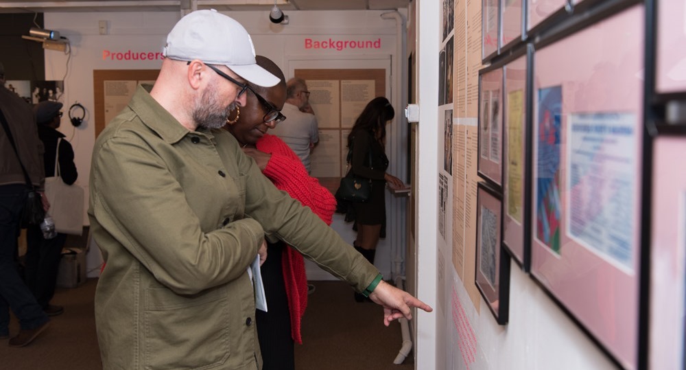 Two guests look at a photograph on a wall at Vestry House