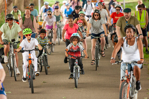 A crowd of cyclists ride together 