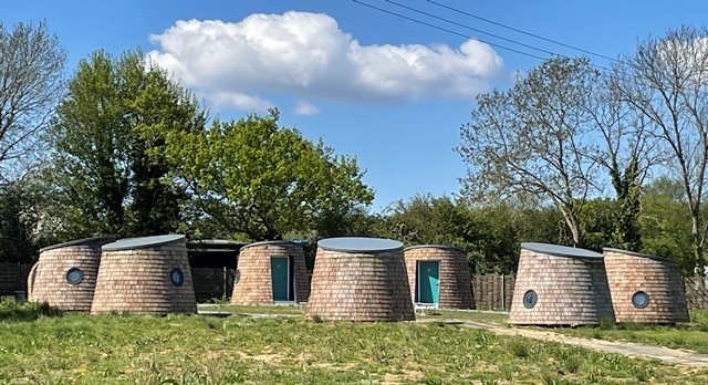 A semi circle of eco pods outside at the Hive