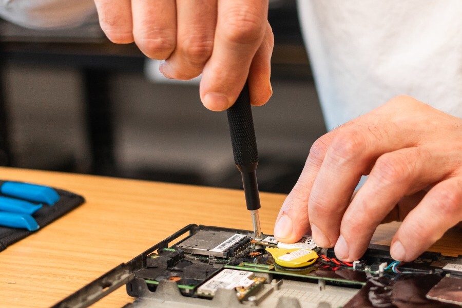 Close up on hands screwing something onto an electrical circuit board