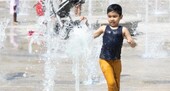 A child laughs while playing in the fountain at Fellowship Square
