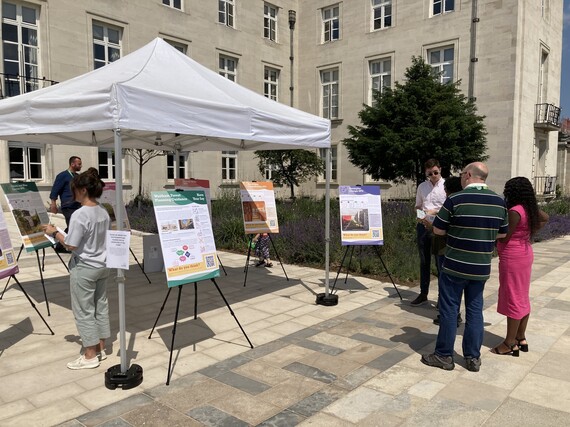 People looking at exhibition boards under a gazebo 