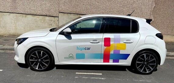 A Hiya car club car parked in the road