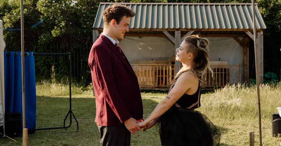 A man and woman in hold hands in a park, staring into each other's eyes lovingly