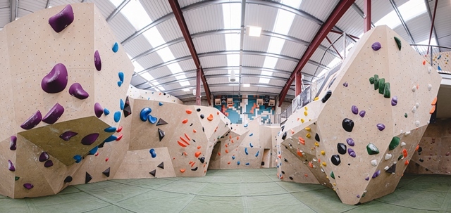 Yonder climbing wall showing multi coloured foot holds on artificial boulders