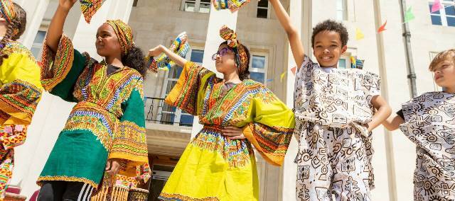 Children dressed in bright colours stand outside Waltham Forest Town Hall