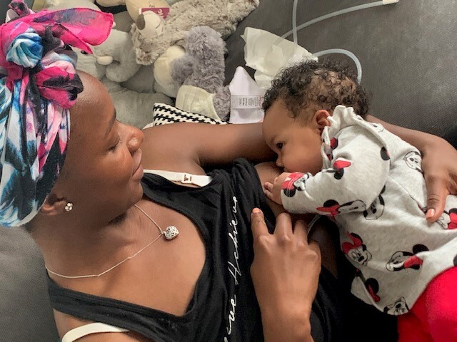 Jocelyn, a Black woman, feeds her young baby 