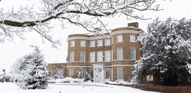 The main entrance of William Morris Gallery, with snow on the grounds and on branches of trees surroudning it