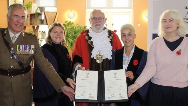 Signatories of the Armed Forces Covenant pose with the document in the Town Hall foyer