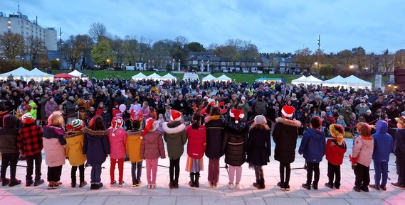 A choir of schoolchildren wearing Santa hats entertain the crowd in Fellowship Square