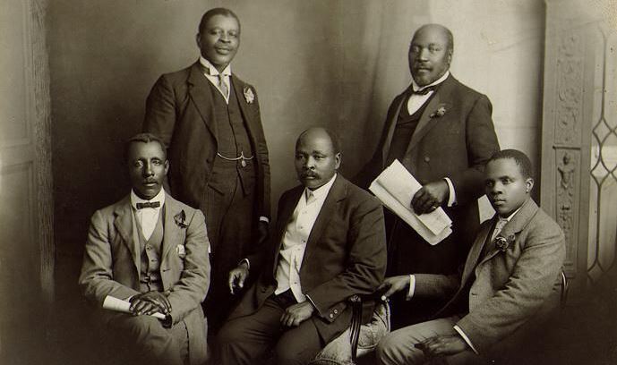 An old black and white photo of a group of men dressed in formal in suits