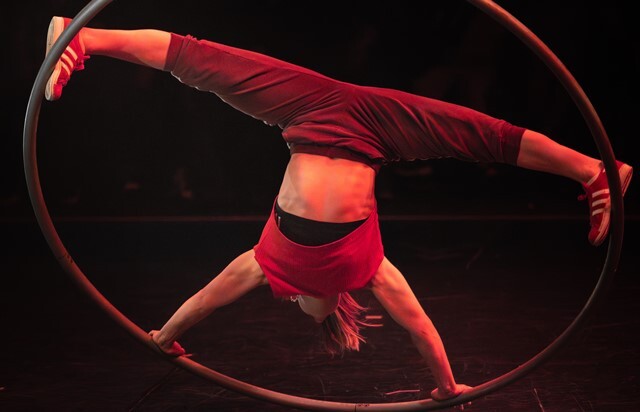 A Revel Puck Circus performer spins in a hoop 