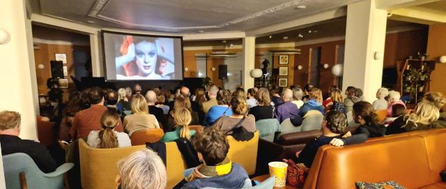 People are pictured from behind as they watch a film from Stow Film Lounge in the foyer of Waltham Forest Town hall