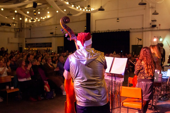 Man playing the cello in a santa hat