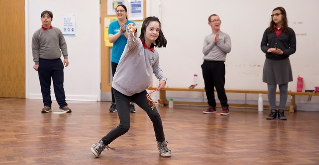 Children watch another child perform in a dance class