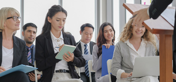 business audience in corporate attentive listening and take note from speaker in seminar event