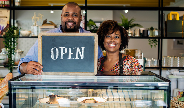 cake cafe business owners with open sign