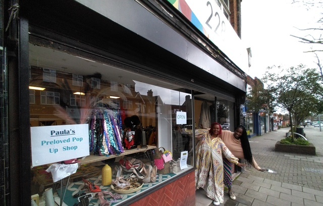 Two women from Paula's Pre-Love Pop-up Shop smile and laugh as they pose in the doorway of 228 Chingford Mount Road