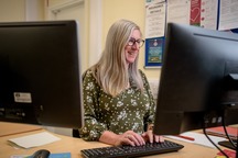 A woman enjoys working on her computer