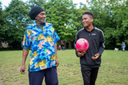 An older man and a teenager play football
